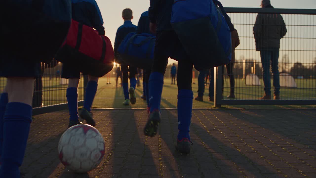 Young players with sports bags on their way to the training pitch